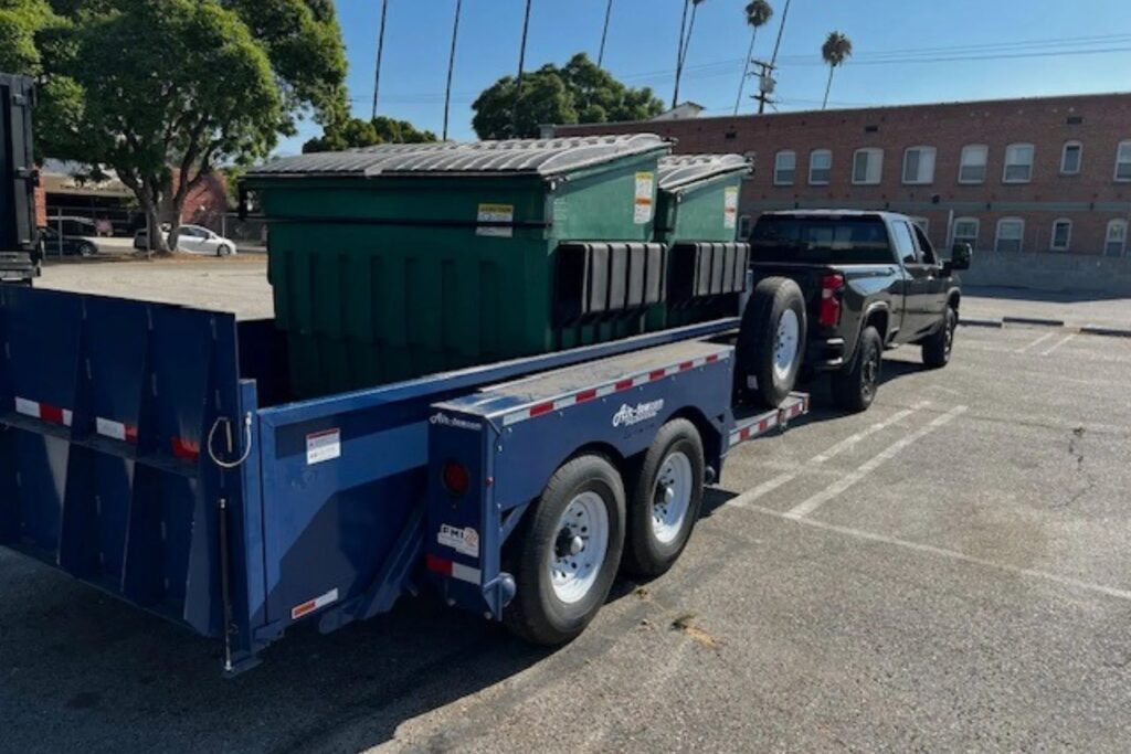 Truck hauling dumpsters on a trailer