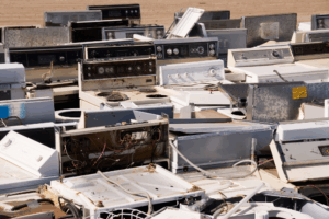 Piled discarded appliances in junkyard